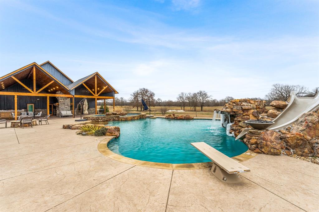 239 32507th Road Paris, TX 75460 - Photo 25 of 40 View of pool with a patio area, a diving board, a water slide, and a pool with connected hot tub