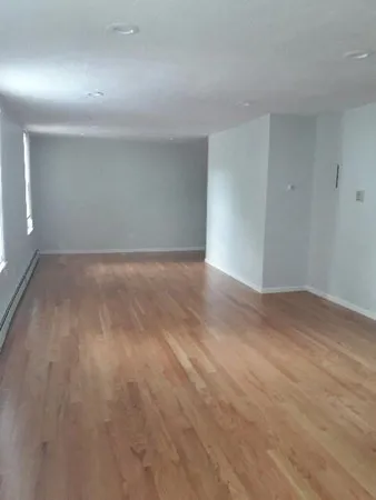 a view of an empty room and wooden floor