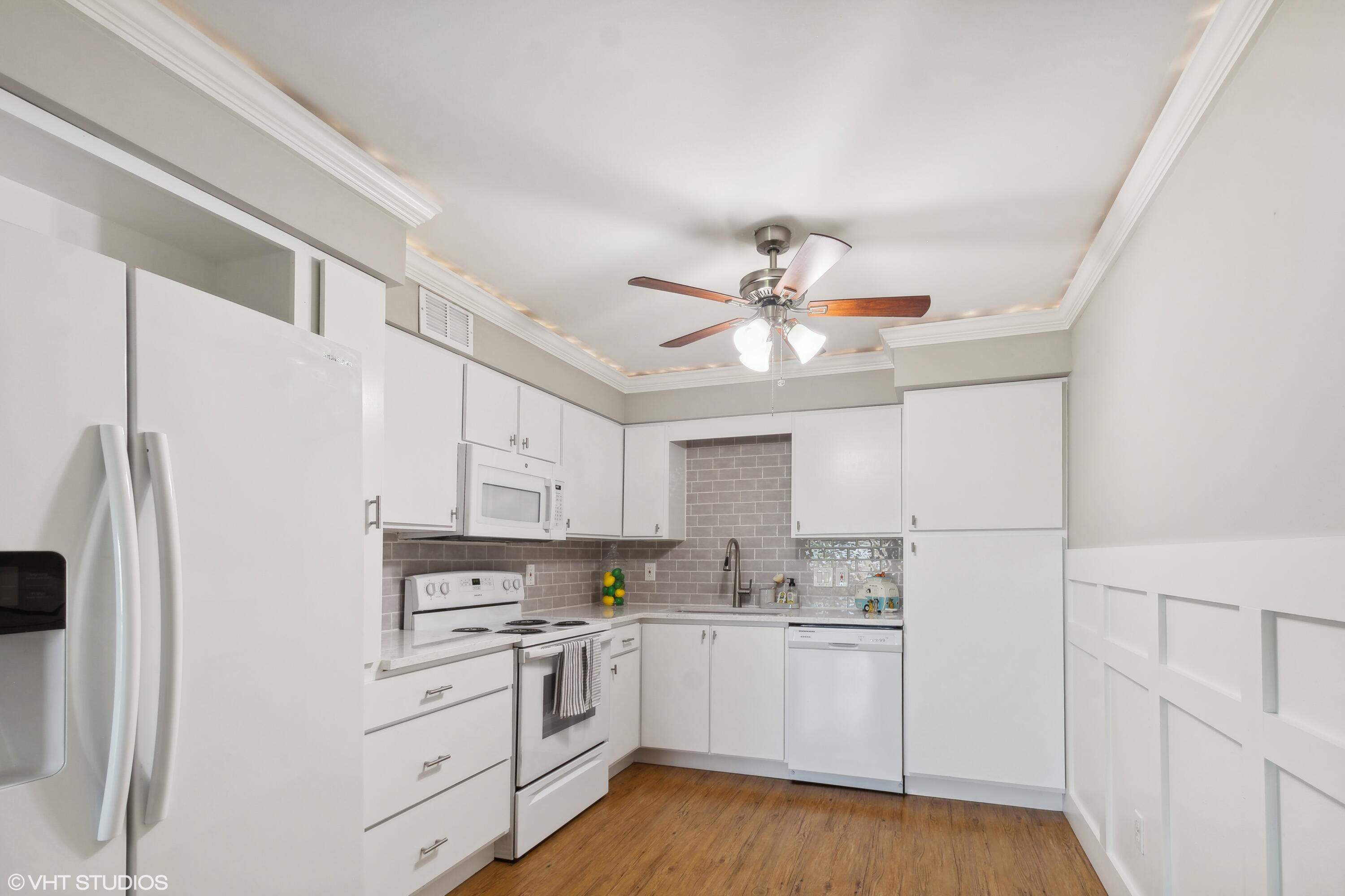 1069 Millpond Road, Unit G Valparaiso, IN 46385 - Photo 2 of 13 a kitchen with a refrigerator a sink and dishwasher with white cabinets
