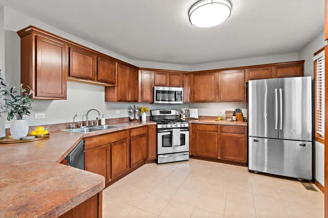 a kitchen with stainless steel appliances granite countertop a sink stove microwave and refrigerator