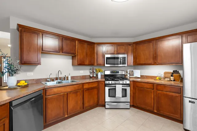 a kitchen with stainless steel appliances granite countertop a stove top oven a sink dishwasher and cabinets with wooden floor