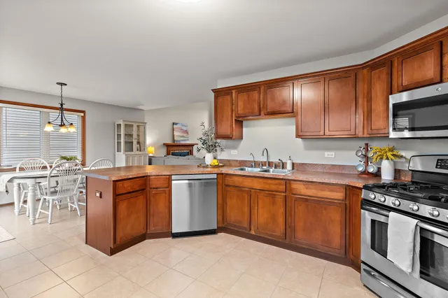 a kitchen with stainless steel appliances granite countertop a refrigerator stove a sink dishwasher and microwave