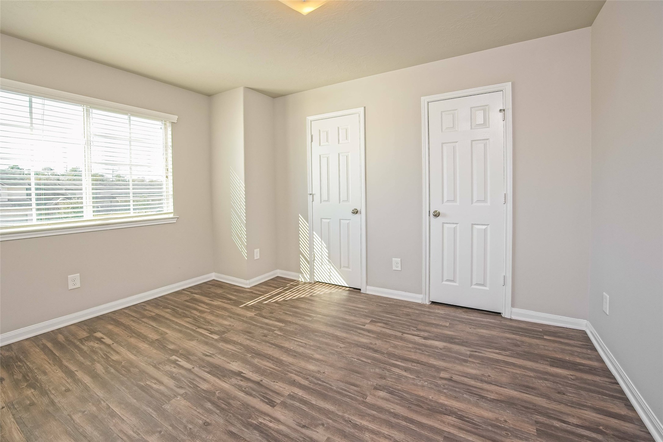 9719 Elia Court Houston, TX 77044 - Photo 10 of 12 a view of an empty room with wooden floor and a window