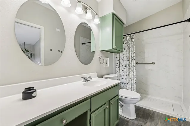 a bathroom with a sink a toilet and a mirror