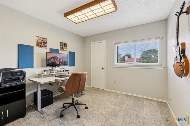 a view of a workspace with furniture and a window