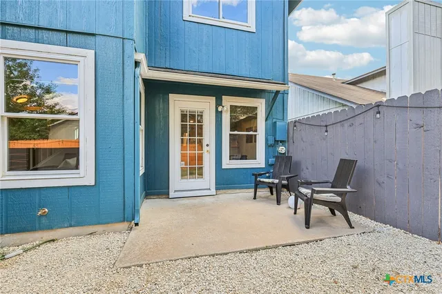 a backyard of a house with table and chairs
