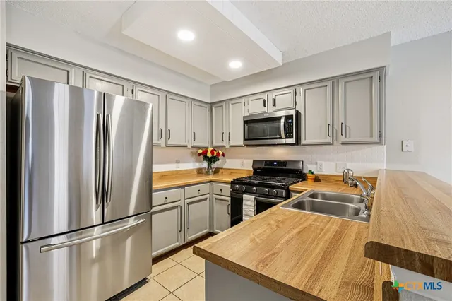 a kitchen with stainless steel appliances granite countertop a refrigerator stove microwave and sink