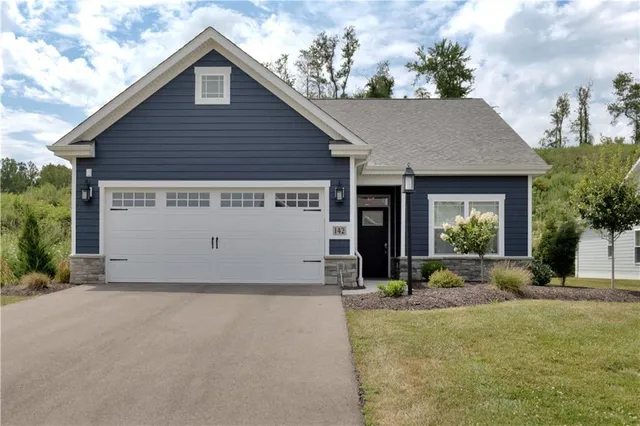 a view of a house with a small yard plants and a table and chairs