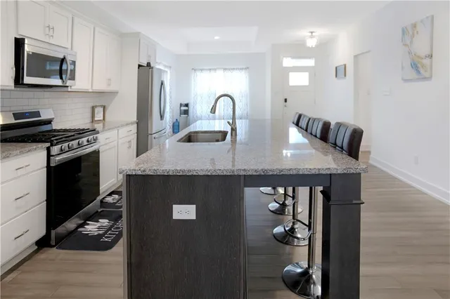 a kitchen with stainless steel appliances granite countertop a sink a stove and cabinets