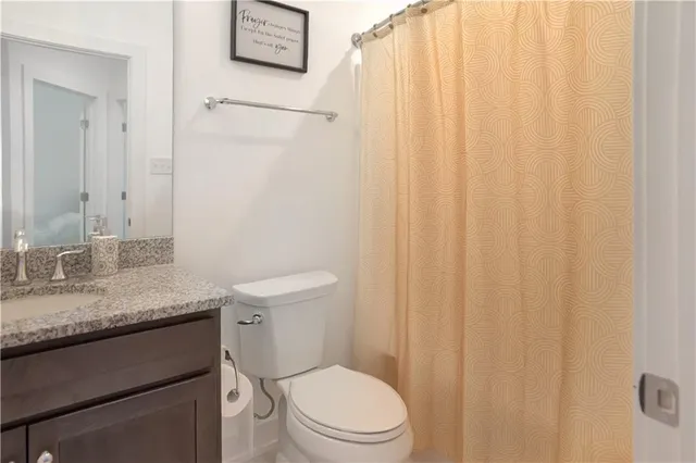a bathroom with a granite countertop toilet and a sink
