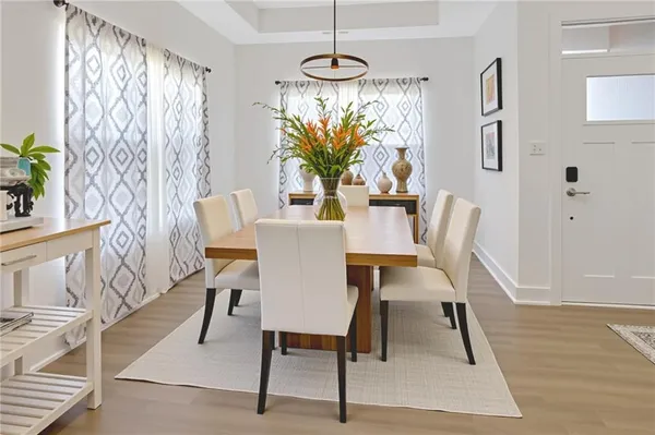 a dining room with furniture potted plants and wooden floor