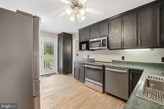 a kitchen with stainless steel appliances granite countertop a refrigerator a stove top oven a sink and dishwasher