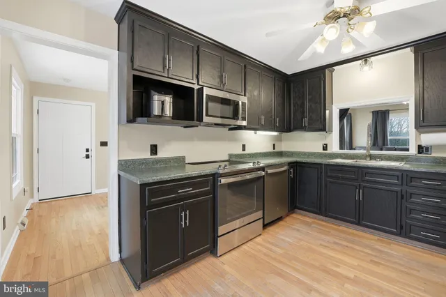 a kitchen with stainless steel appliances granite countertop a stove a sink dishwasher and a microwave oven with cabinets