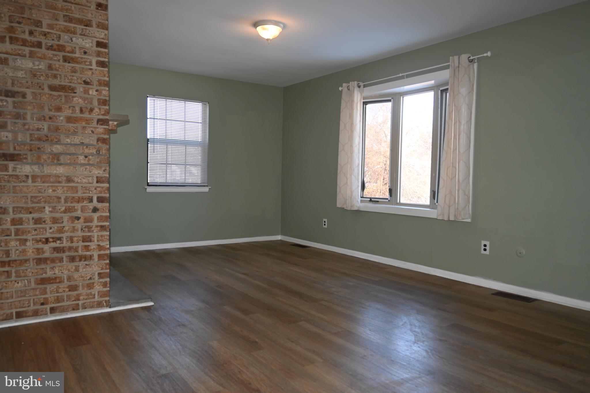 613 St Anthony Lane Upper Darby, PA 19082 - Photo 7 of 30 an empty room with wooden floor and windows