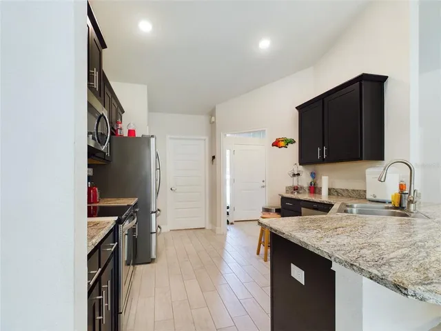 a kitchen with granite countertop a stove and a sink