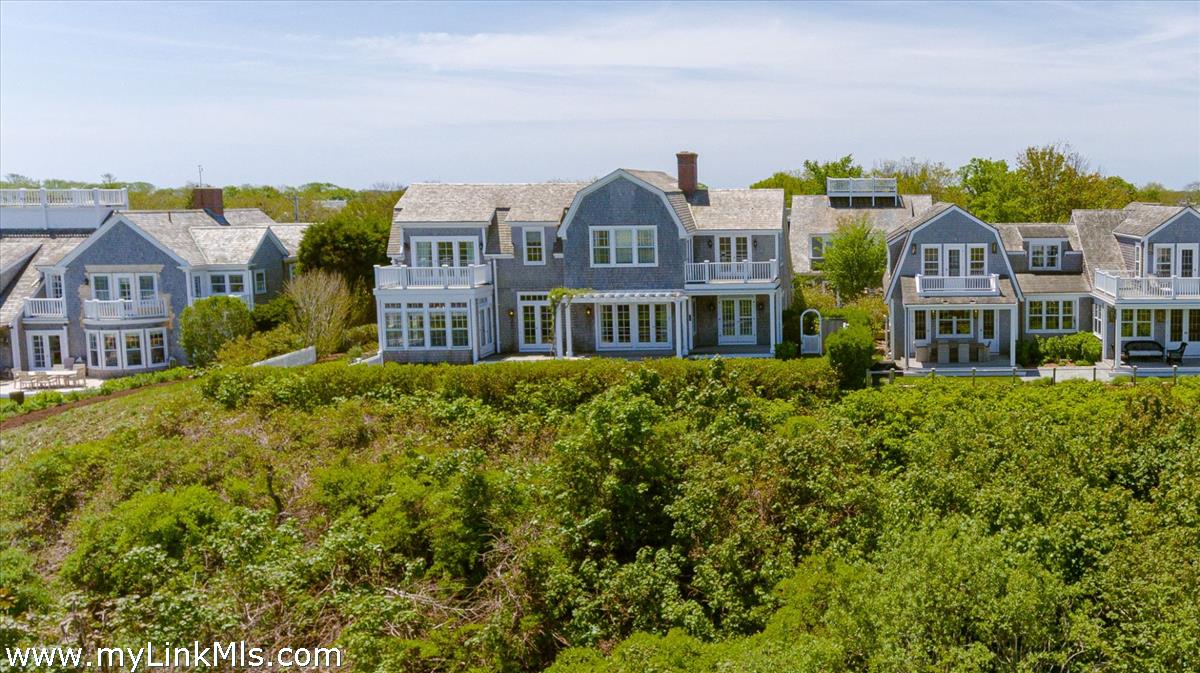 39 Cliff Road Nantucket, MA 02554 - Photo 45 of 46 a front view of a residential apartment building with a yard