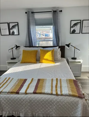 a bed sitting in a bedroom next to a window