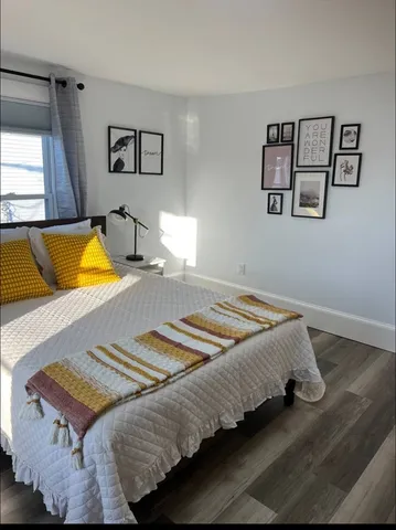 a bedroom with bed and painting on the wall