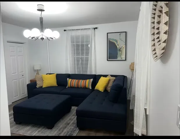 a living room with furniture flowerpot and window