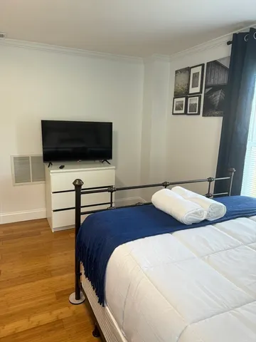 a bedroom with a bed and wooden floor