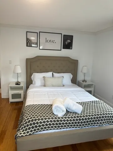 a bedroom with a bed and wooden floor