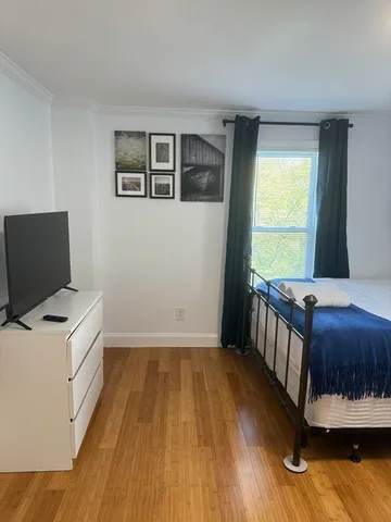 a bedroom with a bed and wooden floor