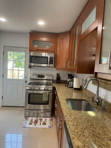 a kitchen with stainless steel appliances granite countertop a sink stove and microwave