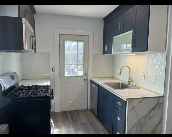 a kitchen with stainless steel appliances granite countertop a sink stove and cabinets