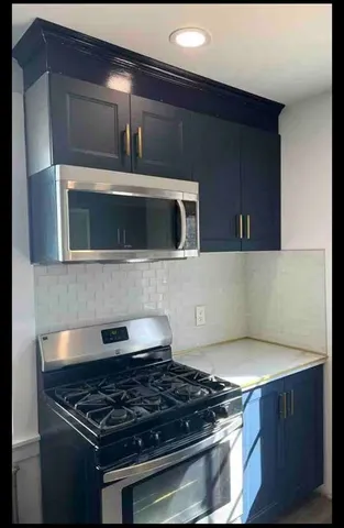 a kitchen with granite countertop a stove and a microwave