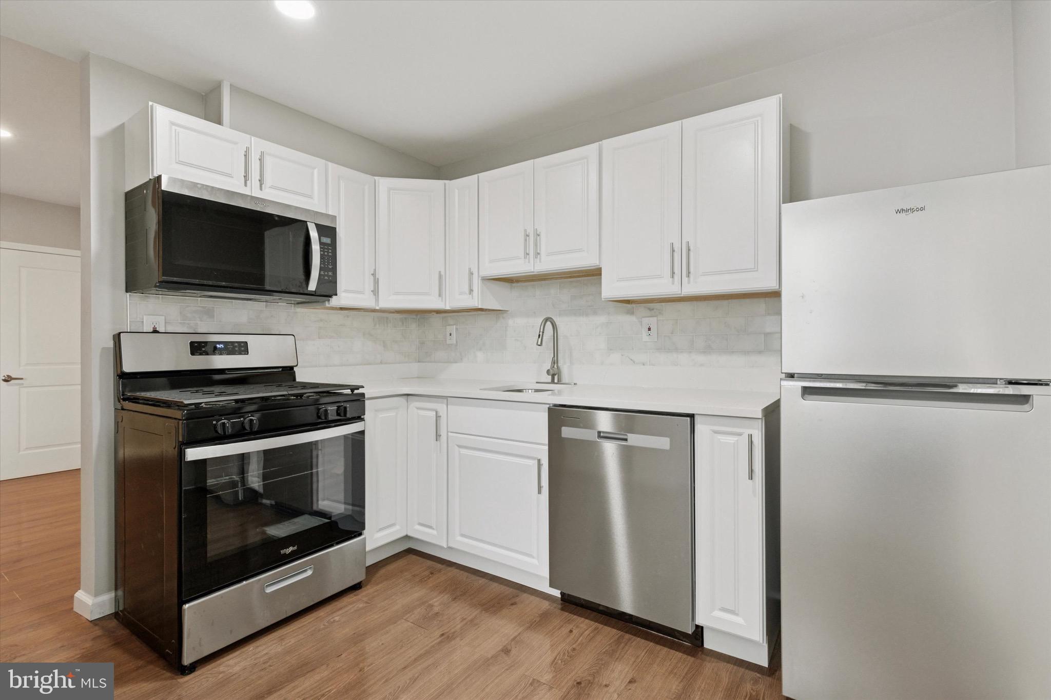 234 Main Street Hellertown, PA 18055 - Photo 3 of 13 a kitchen with stainless steel appliances white cabinets white stove a microwave and a refrigerator