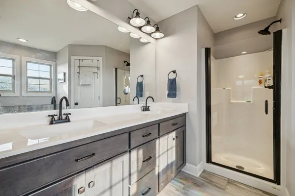 a bathroom with a double vanity sink mirror and shower