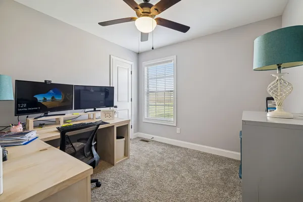 a view of a workspace with furniture and a flat screen tv