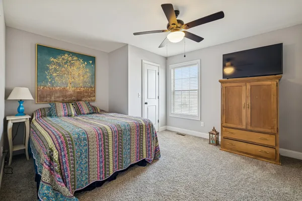 a spacious bedroom with a bed and a chandelier