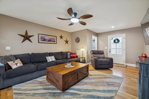 a living room with furniture a ceiling fan and a rug