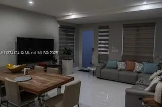 a kitchen with stainless steel appliances kitchen island granite countertop a table chairs stove and refrigerator