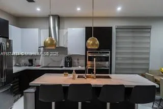 a kitchen with stainless steel appliances a sink and a refrigerator