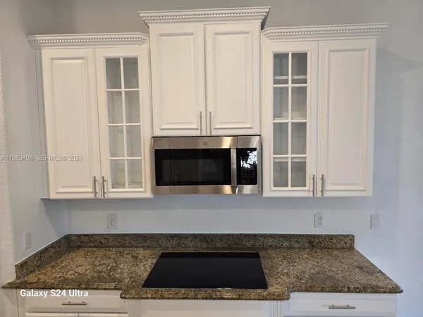 a bathroom with a granite countertop sink a toilet and mirror