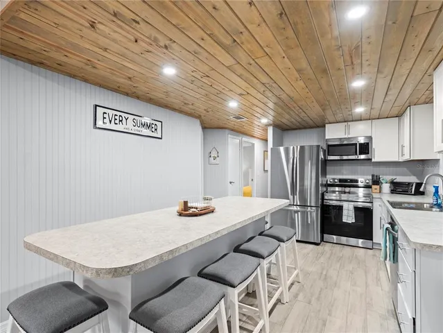 a kitchen with stainless steel appliances granite countertop a refrigerator a stove top oven a sink and dishwasher