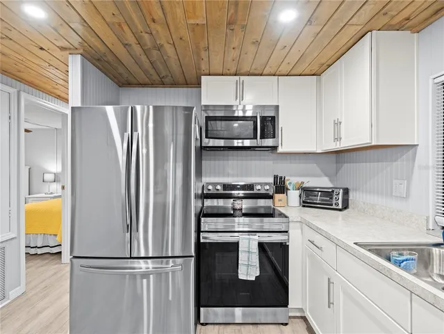a kitchen with cabinets appliances a sink and a window