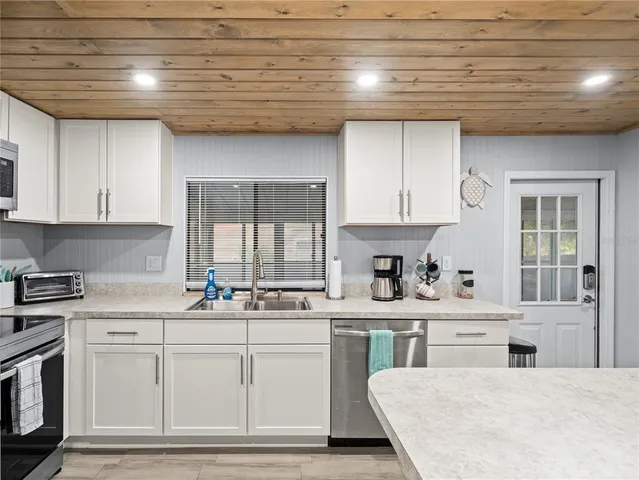 a kitchen that has a sink a stove and chairs