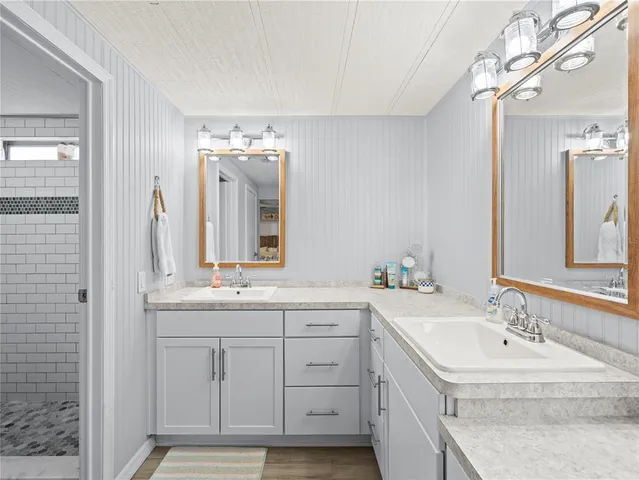 a bathroom with a double vanity sink and mirror