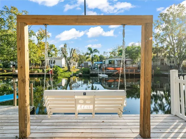 a view of a swimming pool with a bench and some trees