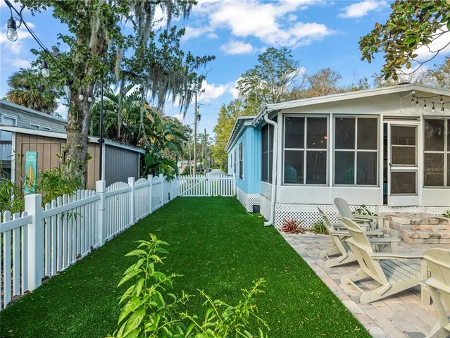 a view of a patio with dining table and chairs with wooden fence