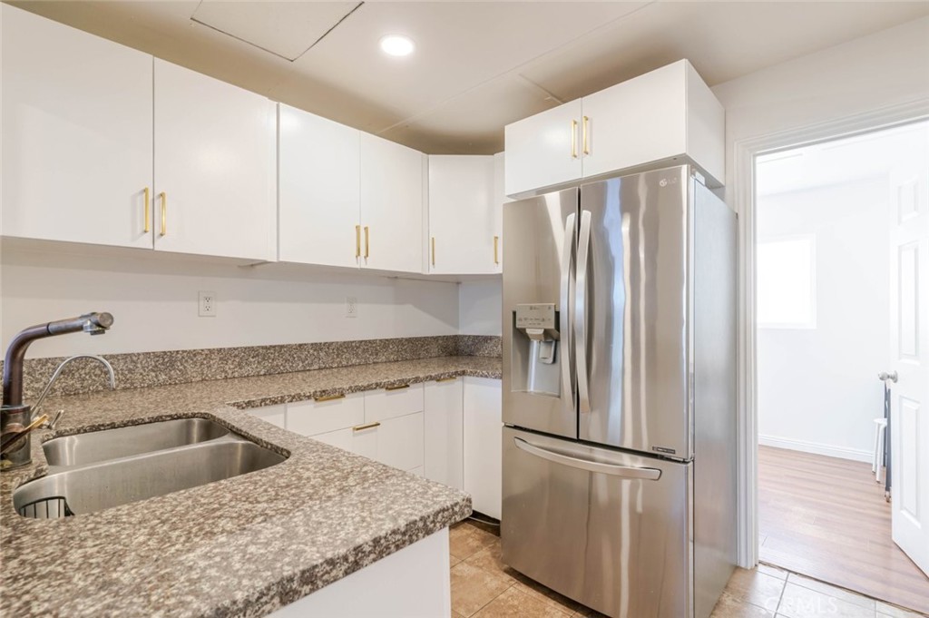 10434 Irma Avenue Tujunga, CA 91042 - Photo 3 of 29 a kitchen with a refrigerator a sink and cabinets