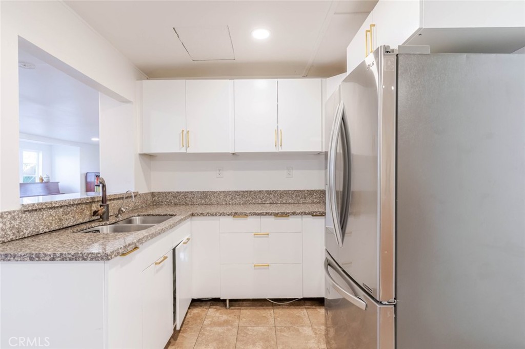10434 Irma Avenue Tujunga, CA 91042 - Photo 4 of 29 a kitchen with a sink a refrigerator a microwave and cabinets