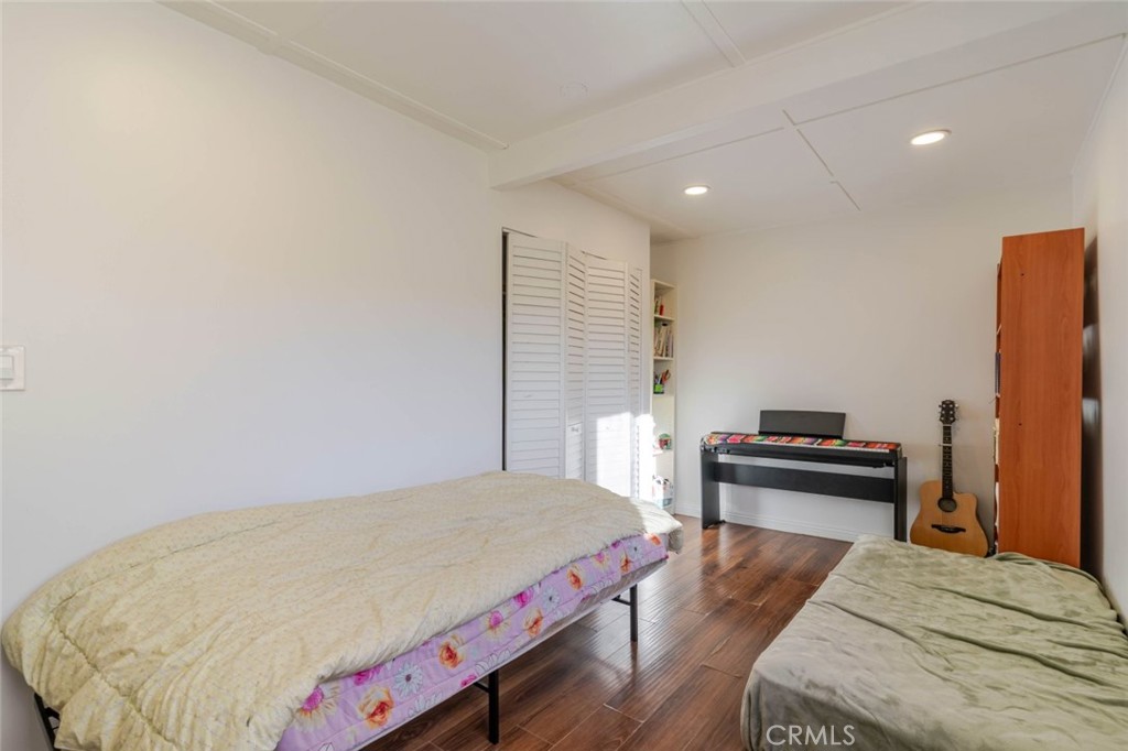 10434 Irma Avenue Tujunga, CA 91042 - Photo 9 of 29 a bedroom with a bed and wooden floor