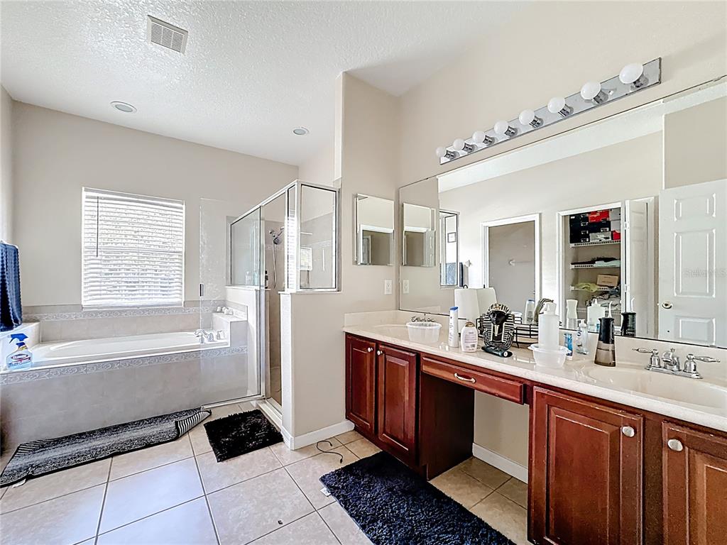 1692 Scrub Jay Road Apopka, FL 32703 - Photo 18 of 35 a spacious bathroom with a double vanity sink a mirror and a bathtub