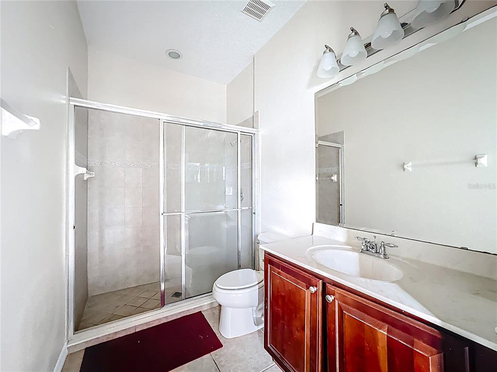 1692 Scrub Jay Road Apopka, FL 32703 - Photo 9 of 35 a spacious bathroom with a double vanity sink toilet and shower