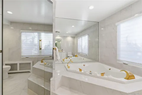 a bathroom with a tub a sink and a window