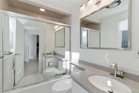 a bathroom with a granite countertop sink mirror and shower